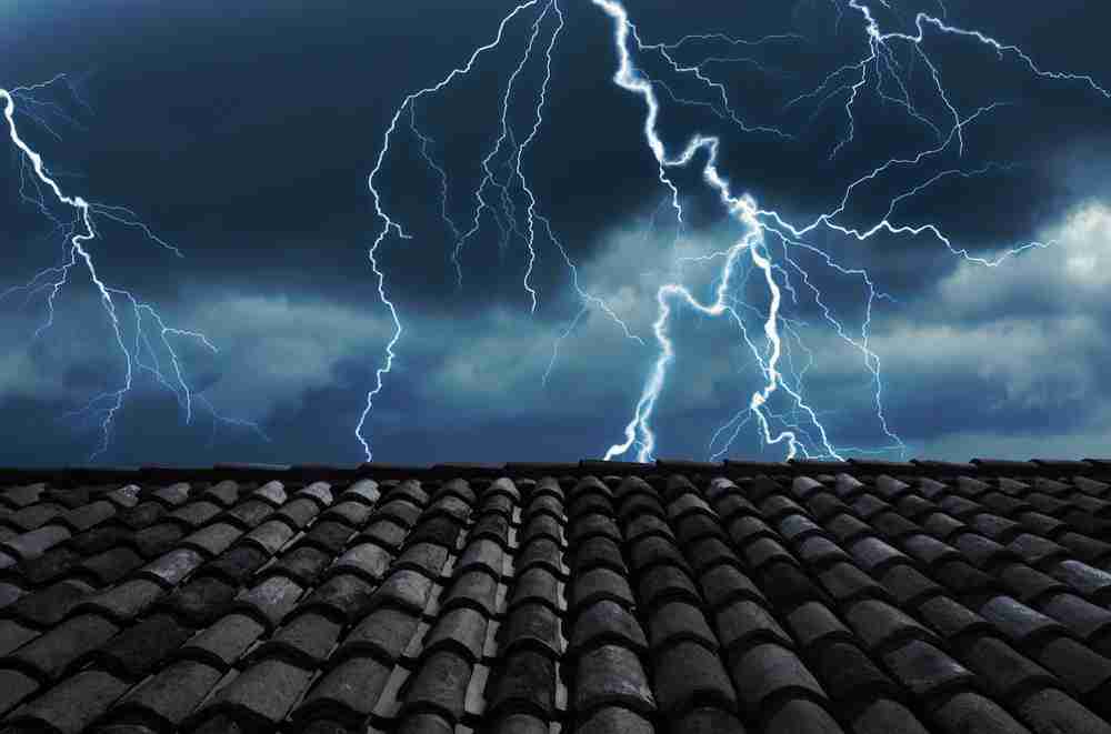 A roof with lightning striking in the background