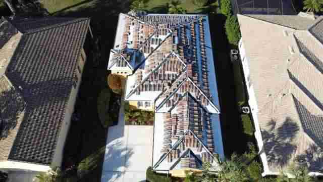 Tile roof under construction as seen from above, flanked by two other homes