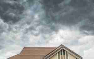 Dark clouds growing over a home with a tile roof