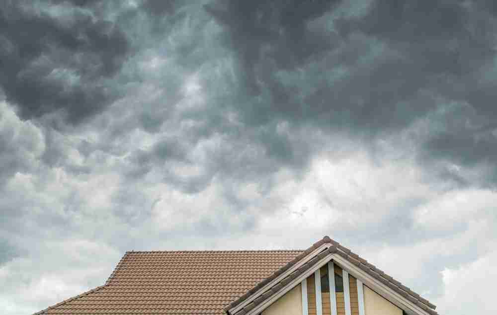 Dark clouds growing over a home with a tile roof